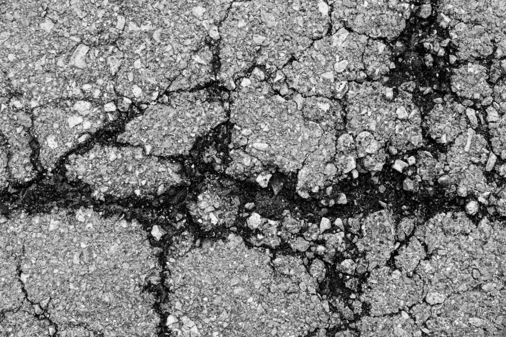 cropped background texture of rough Cracked asphalt.